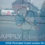 Perforated frosted window film with a custom printed design, close-up, back-side, looking through the glass